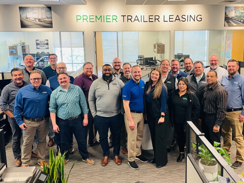 Happy Premier Trailer Leasing team posing for a group picture in the office